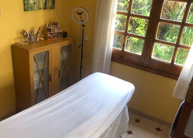 Sala de tratamiento en Cris Falcão Beauty PMU, Cambrils, Cataluña, ES con luz natural y decoración acogedora.