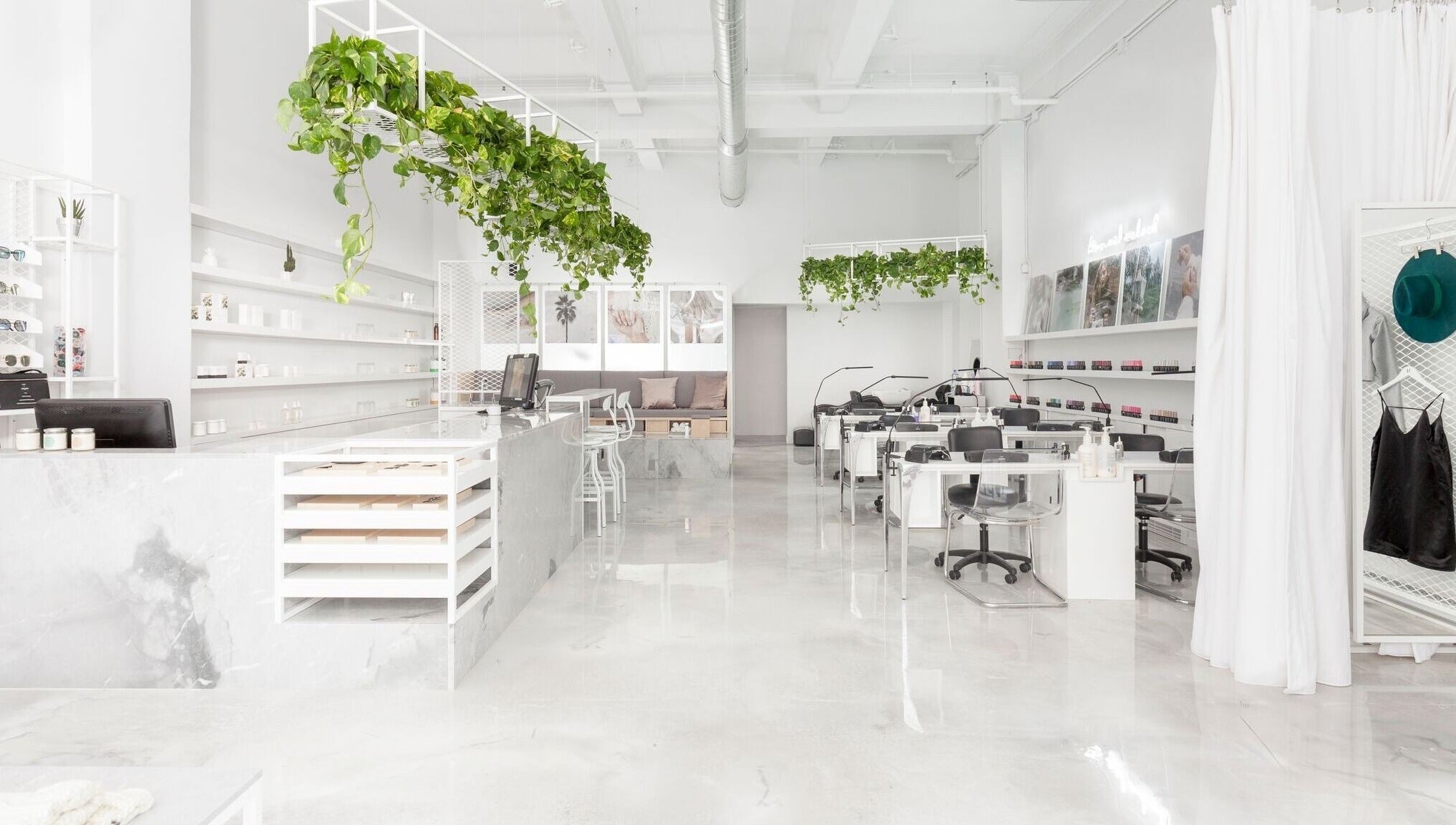 Intérieur lumineux du spa Le Manoir à Montréal, Québec, CA avec des plantes suspendues et un décor épuré.