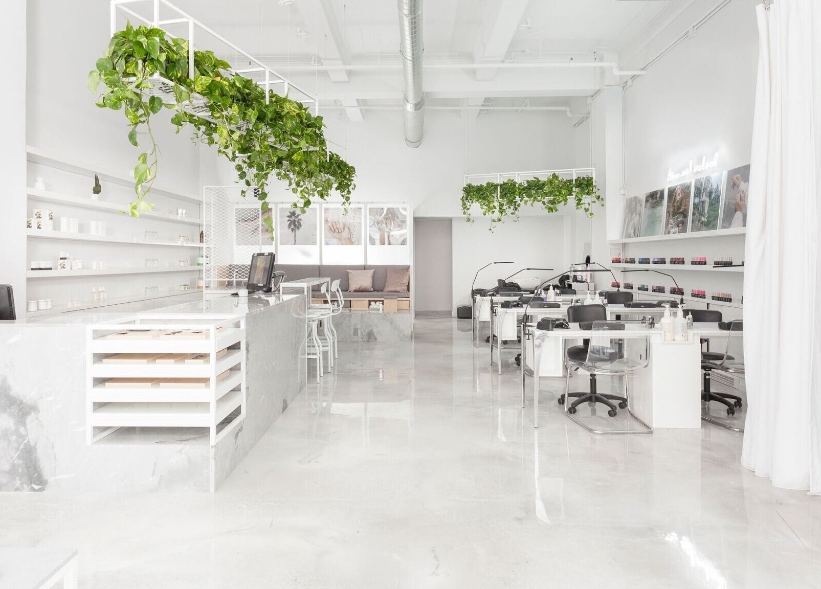 Intérieur lumineux du spa Le Manoir à Montréal, Québec, CA avec des plantes suspendues et un décor épuré.