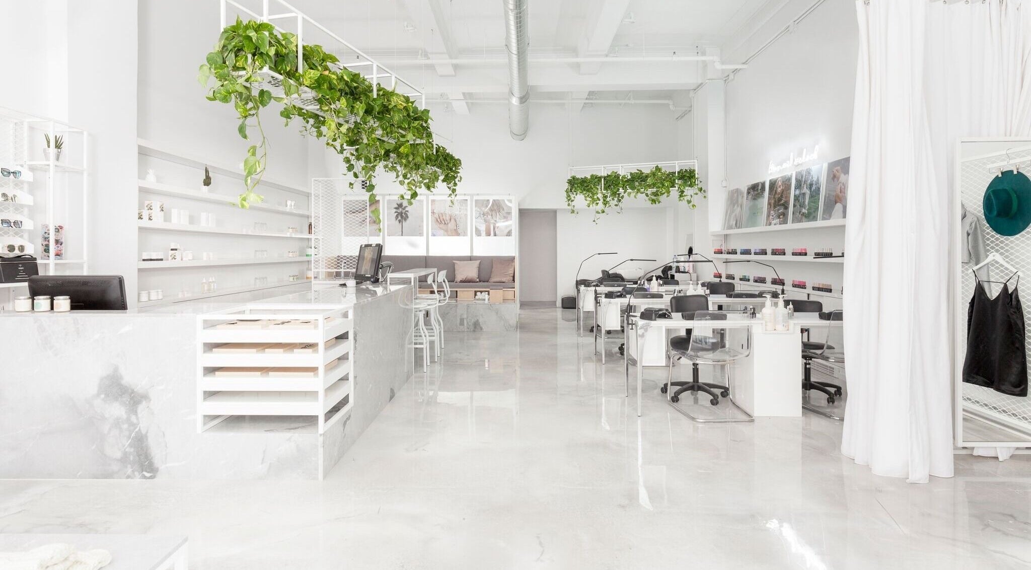 Intérieur lumineux du spa Le Manoir à Montréal, Québec, CA avec des plantes suspendues et un décor épuré.