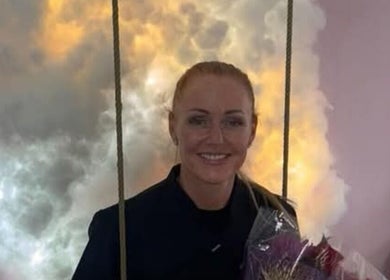 Cozy lounge at By Donna, Doncaster, England, GB with a woman holding flowers against a cloudy backdrop.