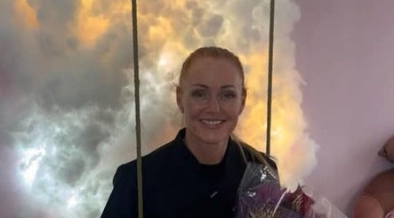 Cozy lounge at By Donna, Doncaster, England, GB with a woman holding flowers against a cloudy backdrop.