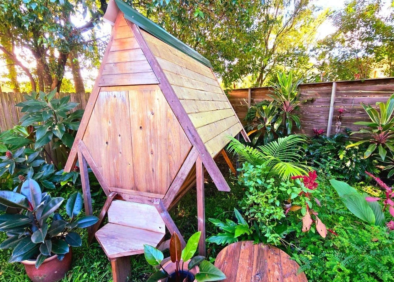 Serene garden view at Bee Alive, Mullumbimby, New South Wales, AU, featuring lush greenery and wooden structure.