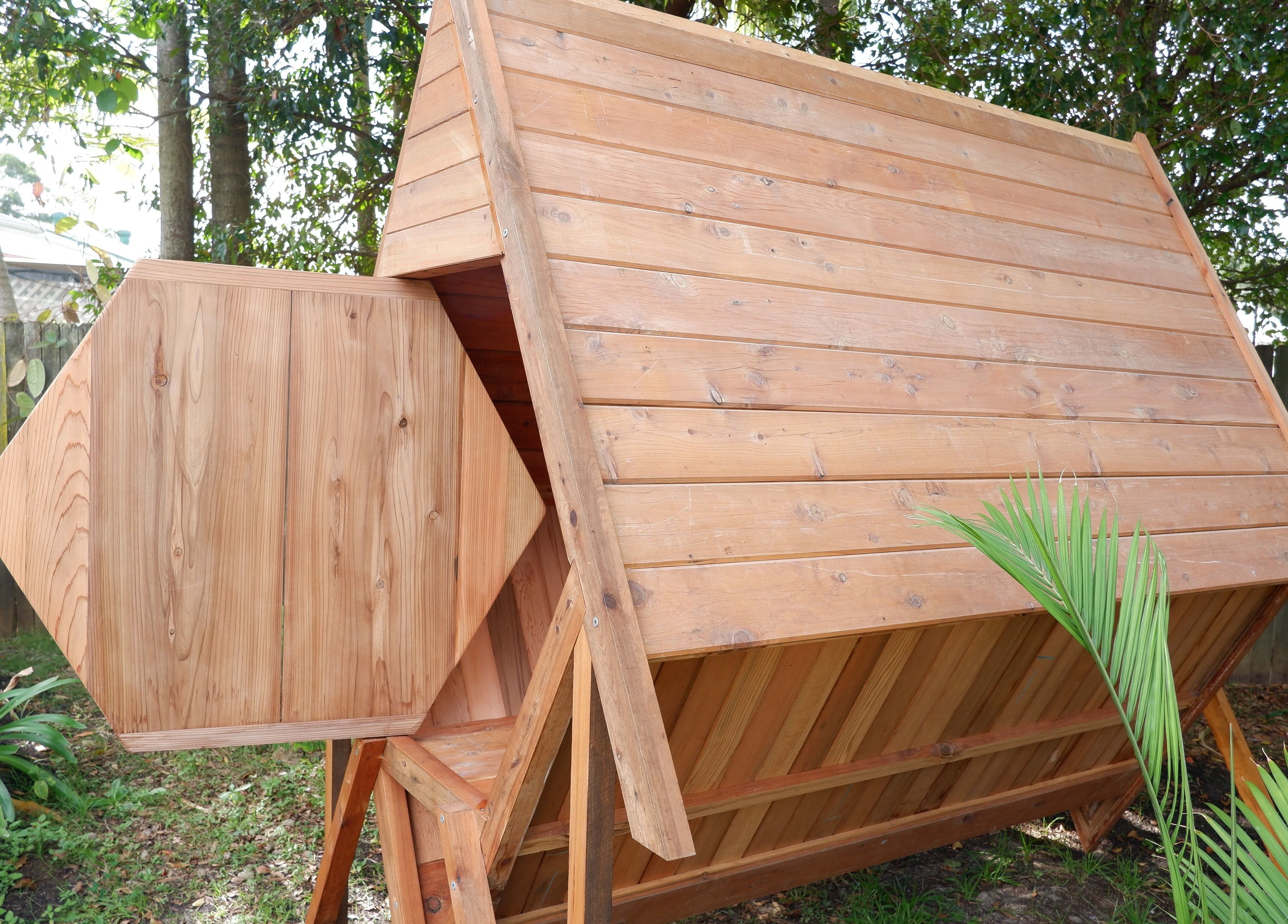 Wooden hut at Bee Alive in Mullumbimby, New South Wales, AU surrounded by lush greenery.