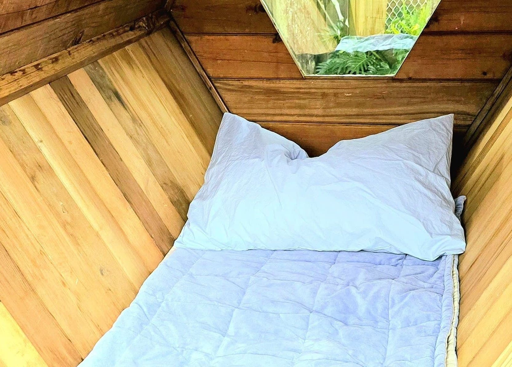 Wooden wellness retreat bed at Bee Alive in Mullumbimby, New South Wales, AU. Experience comfort and relaxation.