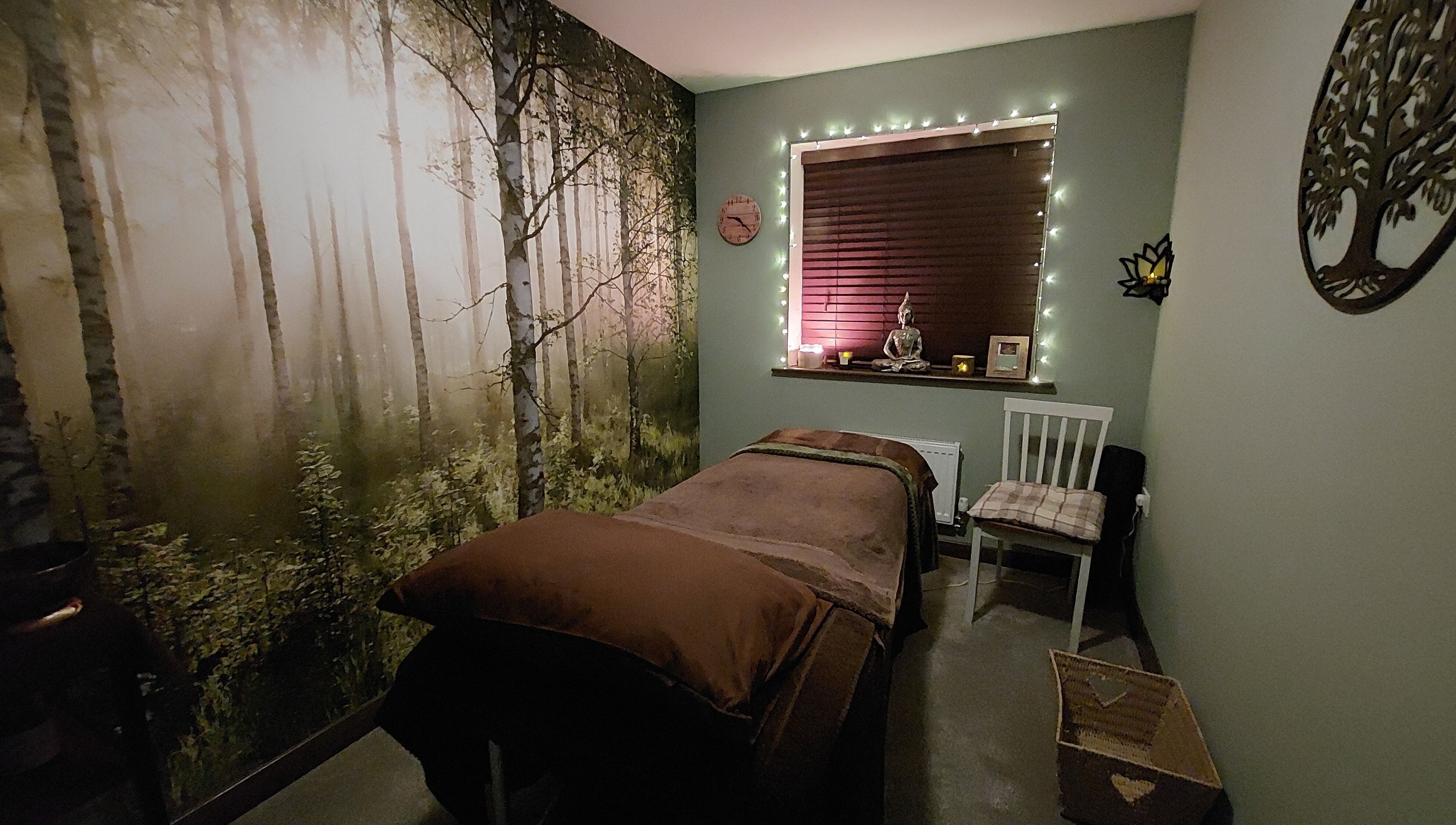 Tranquil spa room at Forest Massage Therapies, Saint Helens, featuring forest mural and soft lighting.