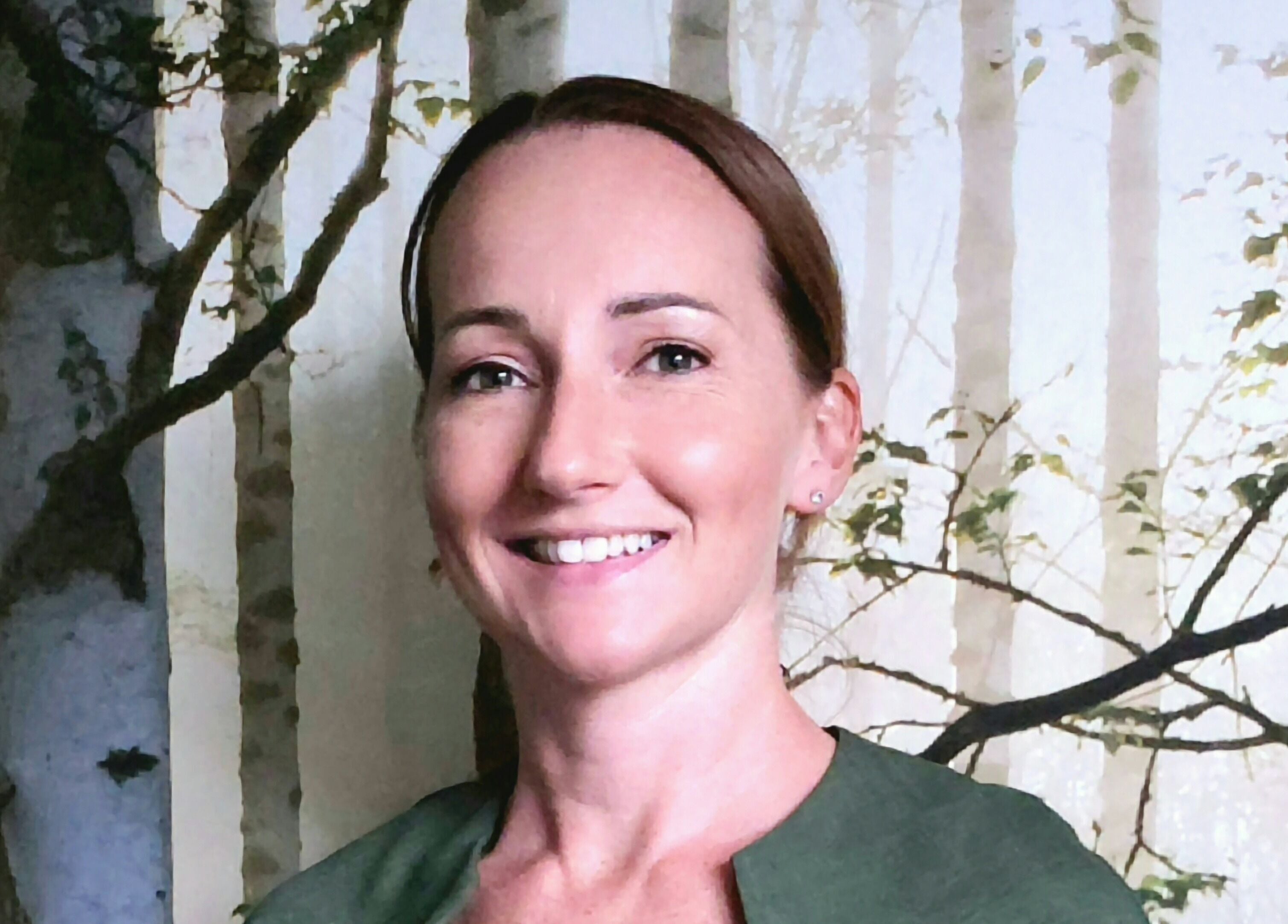 Smiling therapist at Forest Massage Therapies, Saint Helens, England, GB with a forest backdrop.