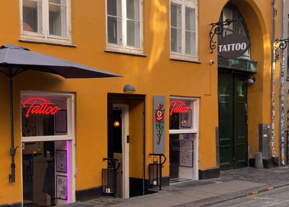 Ug Tattoo i København, Danmark DK med farverig facade og stilfuldt neonskilt.
