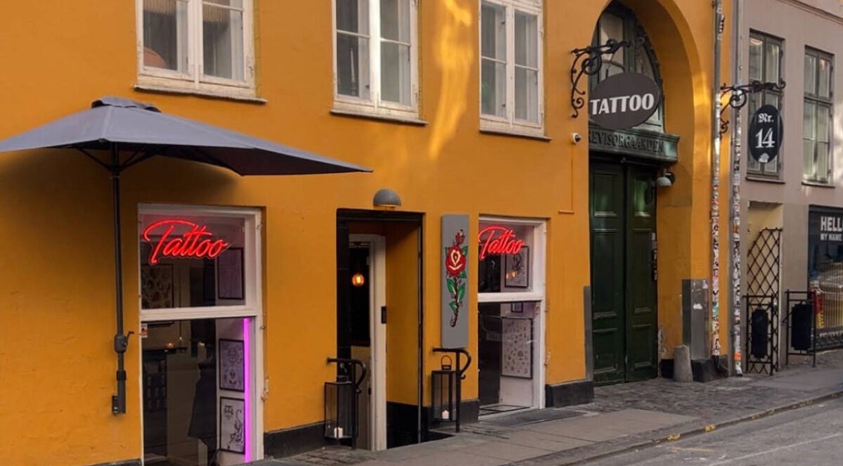 Ug Tattoo i København, Danmark DK med farverig facade og stilfuldt neonskilt.