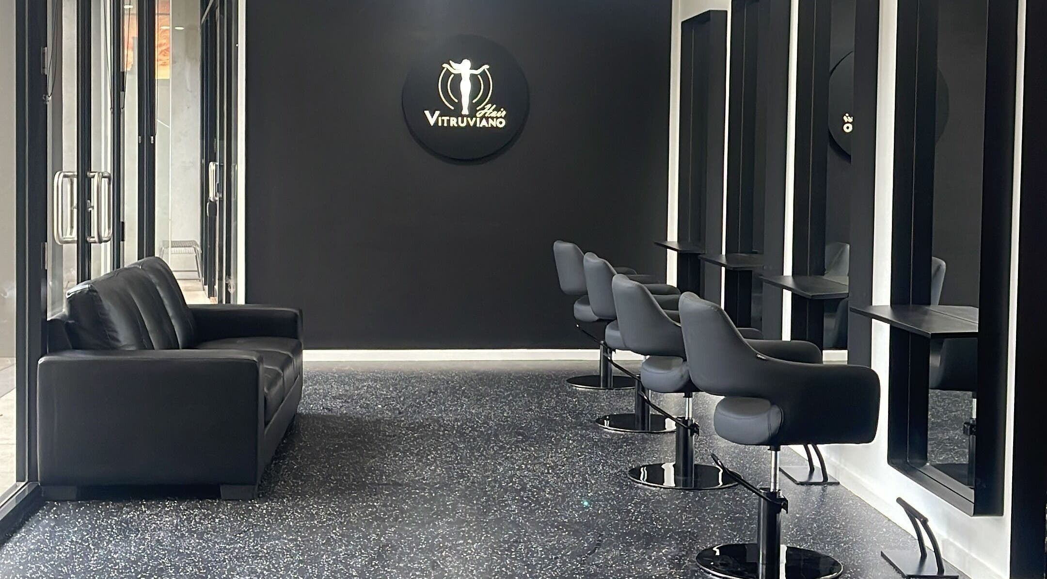 Interior of VITRUVIANO HAIR, Melbourne, Victoria. Modern black chairs and mirrors create a chic salon atmosphere.