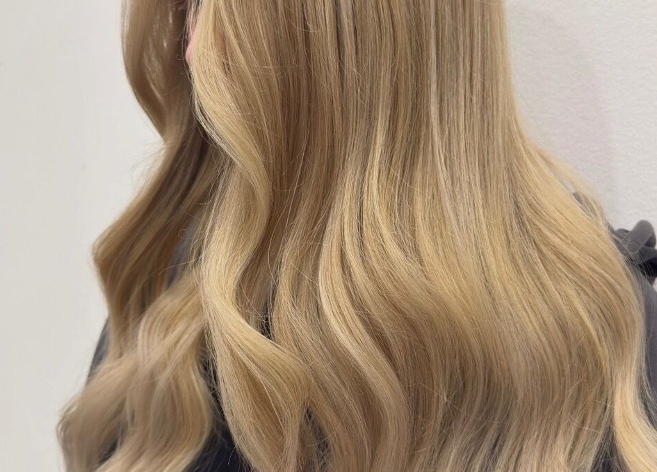 Silky blonde waves styled at Hair with K, Rockdale, New South Wales, AU showcasing vibrant color and shine.
