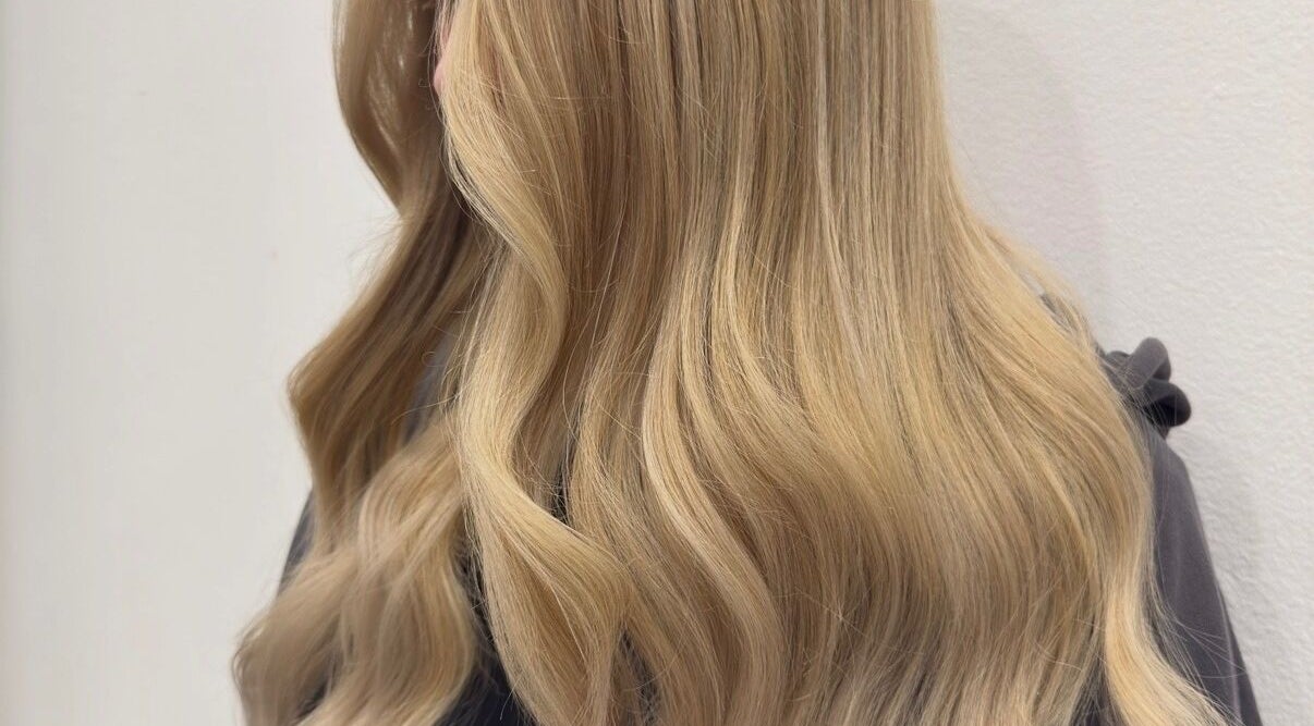 Silky blonde waves styled at Hair with K, Rockdale, New South Wales, AU showcasing vibrant color and shine.