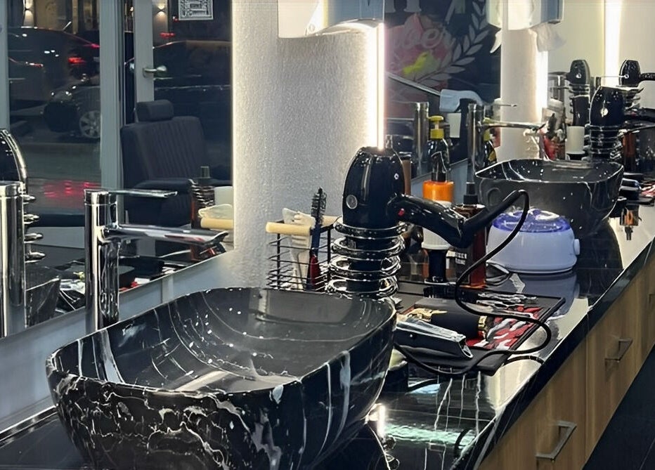 Modern barber station in Barbershop, Durrës, Qarku I Durrësit, AL with sleek black sink and tools.