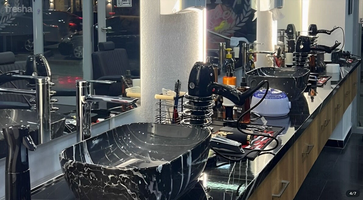 Modern barber station in Barbershop, Durrës, Qarku I Durrësit, AL with sleek black sink and tools.