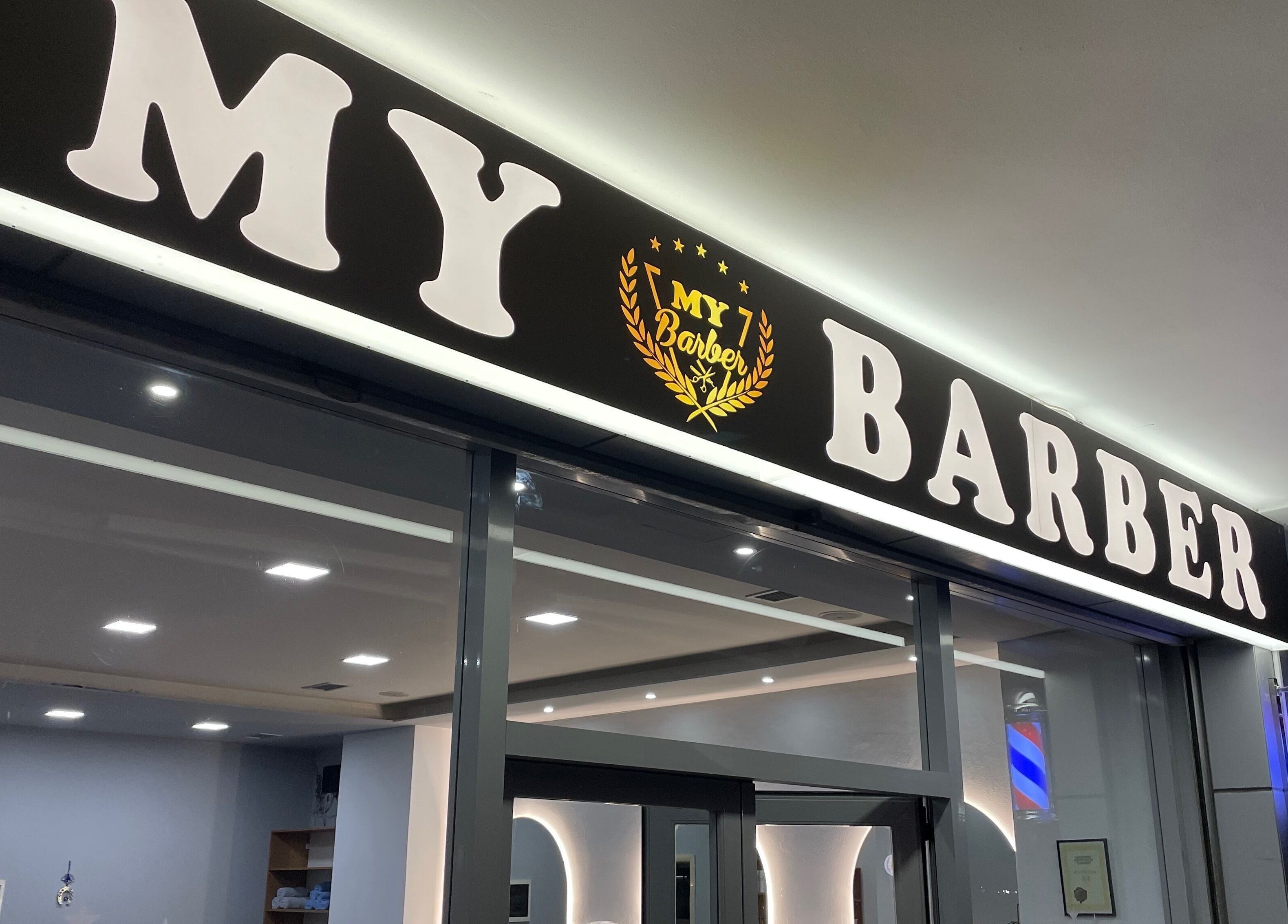 Entrance of Barbershop in Durrës, Qarku I Durrësit, AL, featuring bright signage.