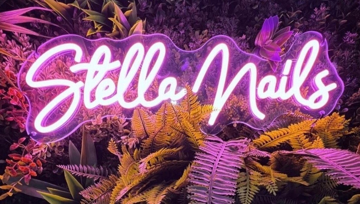 Enseigne néon de Stella Nails entourée de plantes, situé à Bacilly, Normandie, FR.