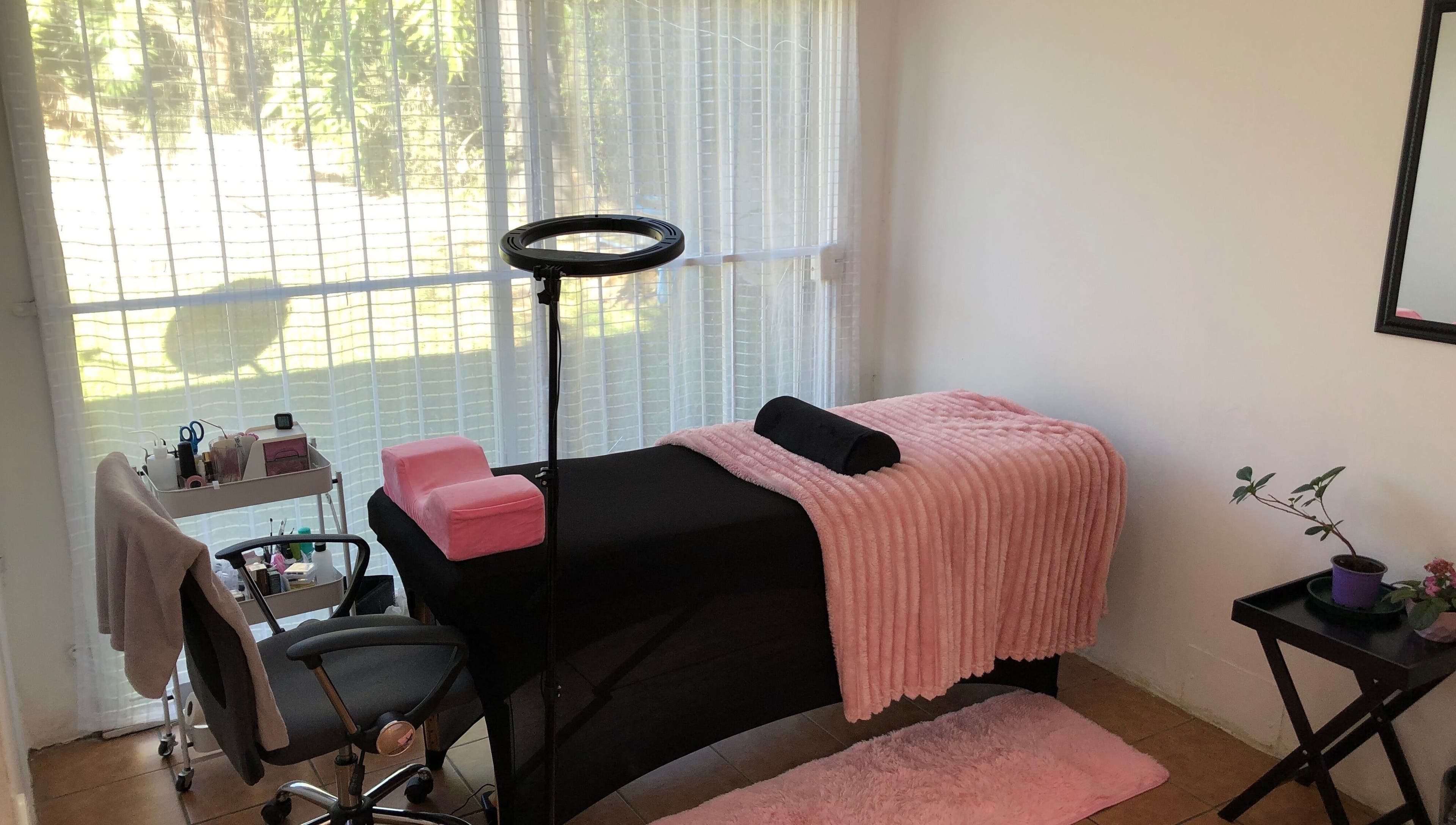 Cozy spa room at Altered Studio, Edenvale, Gauteng, ZA, featuring a massage table with pink accents in bright light.