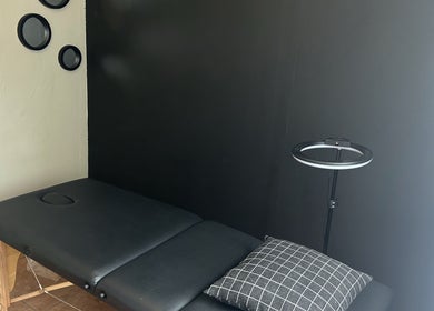 Altered Studio massage room with black bed in Edenvale, Gauteng, ZA.