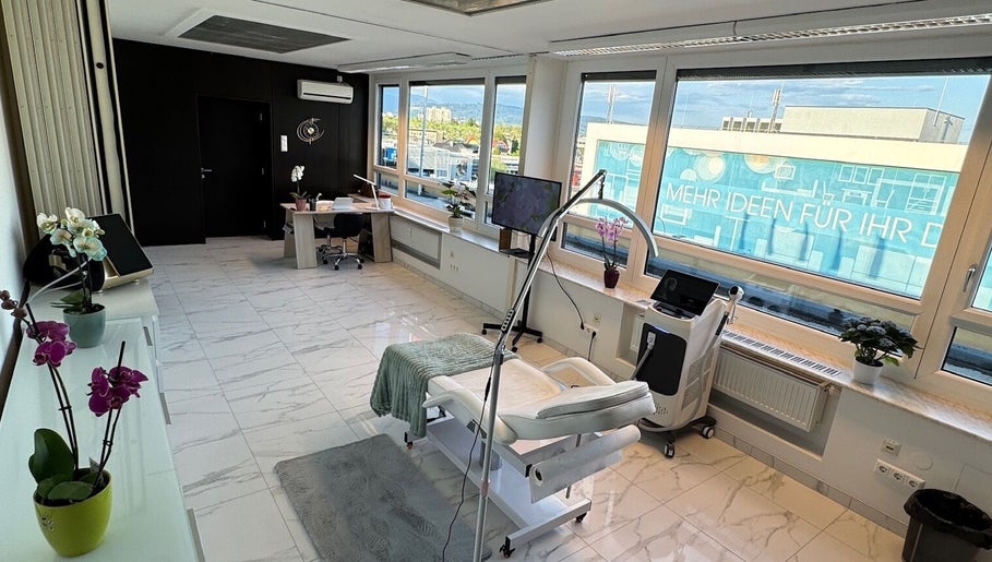 Eleganter Behandlungsraum bei Diamond Aesthetics, Villach, Kärnten, AT mit moderner Ausstattung und großem Fenster.