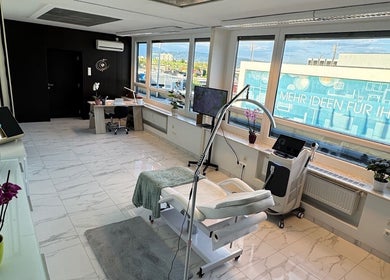 Eleganter Behandlungsraum bei Diamond Aesthetics, Villach, Kärnten, AT mit moderner Ausstattung und großem Fenster.