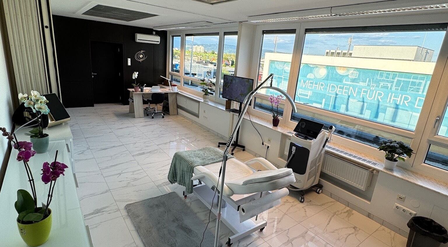 Eleganter Behandlungsraum bei Diamond Aesthetics, Villach, Kärnten, AT mit moderner Ausstattung und großem Fenster.