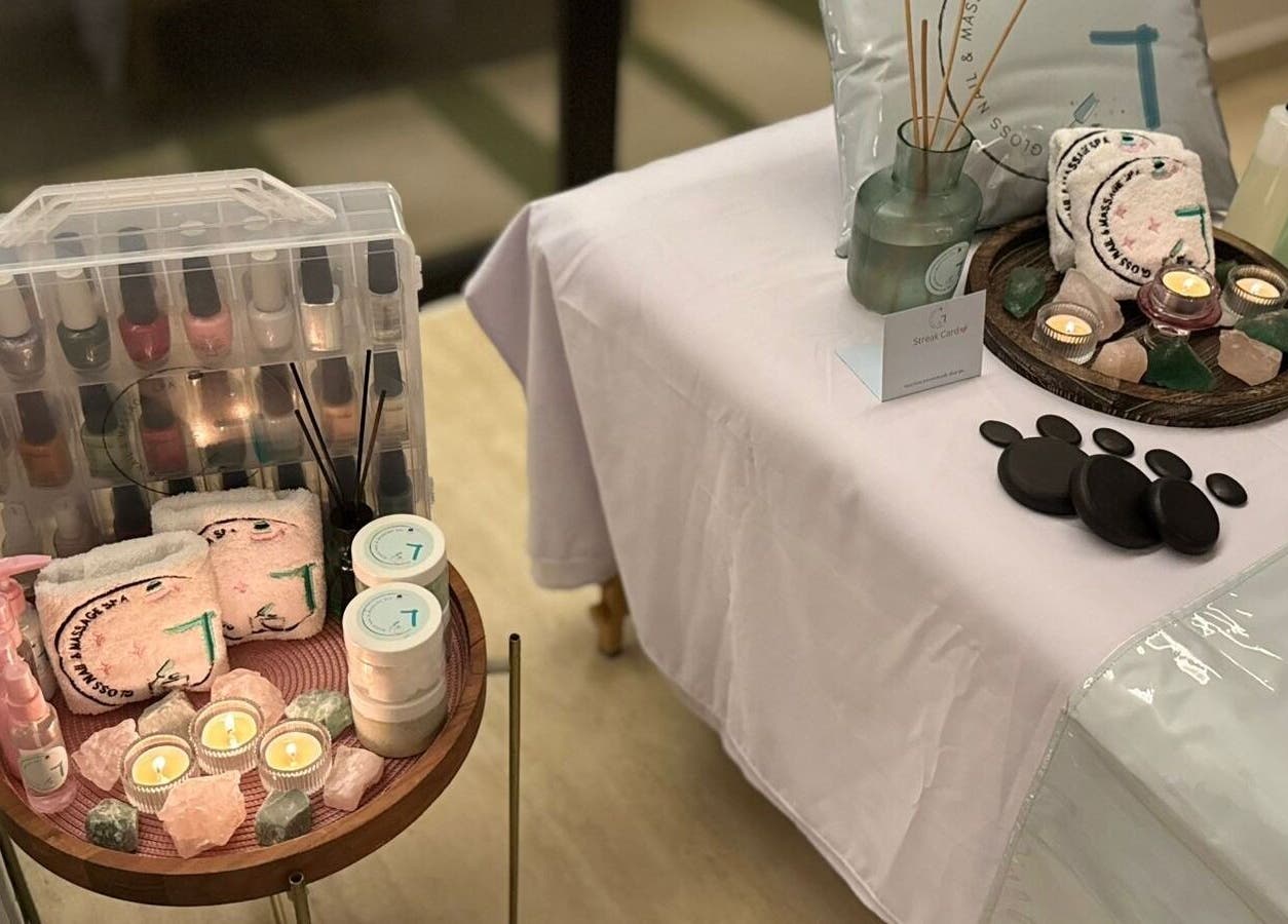 Relaxing spa setup at Gloss Nail & Massage Spa (Home Service), Riyadh with candles and massage stones.
