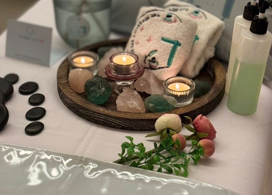 Tranquil massage setup at Gloss Nail & Massage Spa (Home Service), Riyadh, Riyadh Province, SA, with candles and stones.