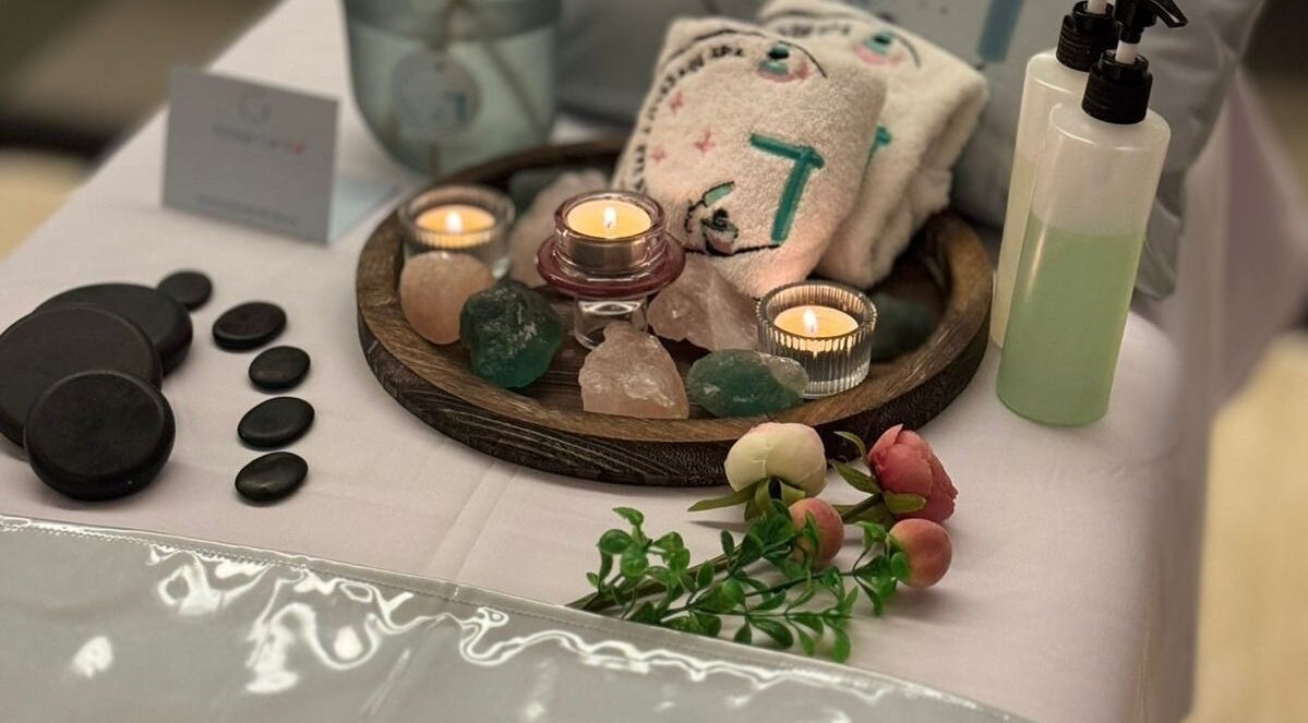 Tranquil massage setup at Gloss Nail & Massage Spa (Home Service), Riyadh, Riyadh Province, SA, with candles and stones.