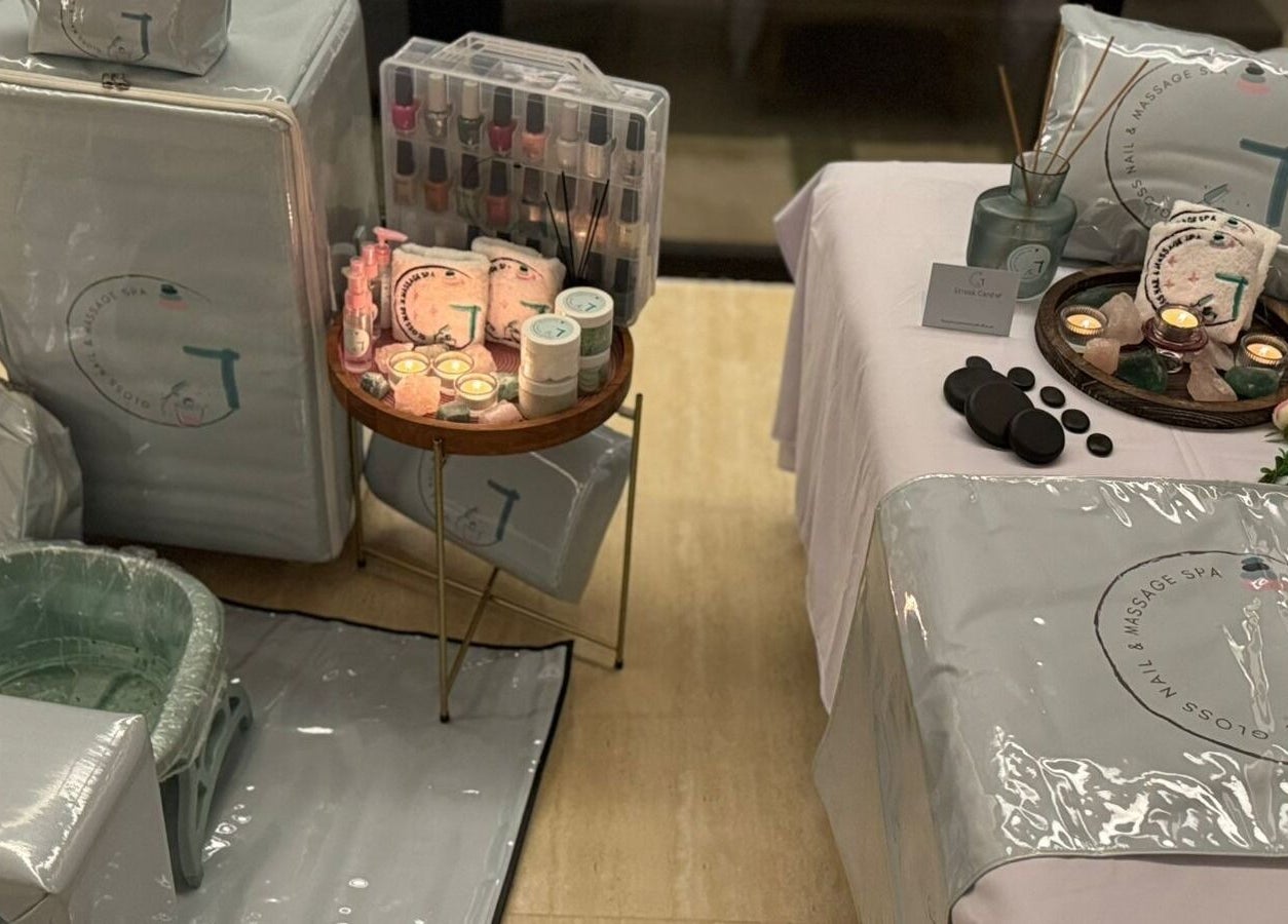 Luxurious setup at Gloss Nail & Massage Spa (Home Service), Riyadh, with candles, massage stones, and spa essentials.