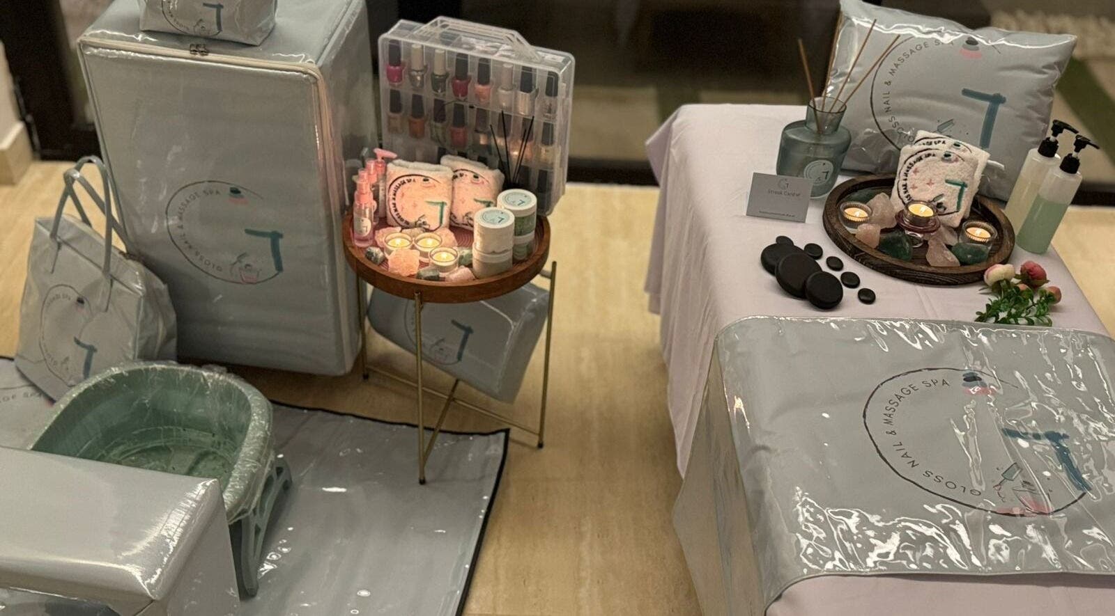 Luxurious setup at Gloss Nail & Massage Spa (Home Service), Riyadh, with candles, massage stones, and spa essentials.