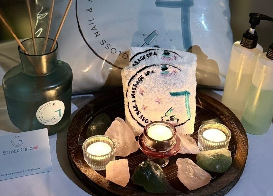 Elegant spa setup at Gloss Nail & Massage Spa (Home Service), Riyadh, Riyadh Province, SA with candles and stones.