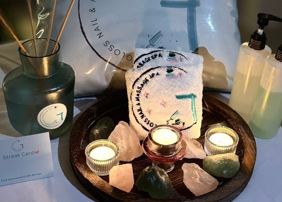 Elegant spa setup at Gloss Nail & Massage Spa (Home Service), Riyadh, Riyadh Province, SA with candles and stones.