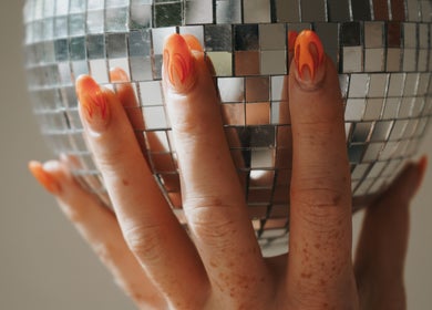 Manicura con diseño fuego sobre bola de espejos en Maru Nails Boutique Beauty Studio, Tulum, Quintana Roo, MX.