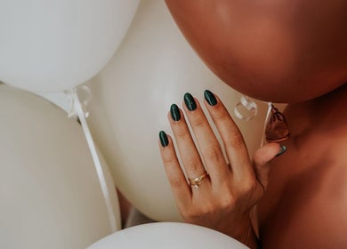 Manicura con esmalte verde en Maru Nails Boutique Beauty Studio, Tulum, Quintana Roo, MX, con globos decorativos.