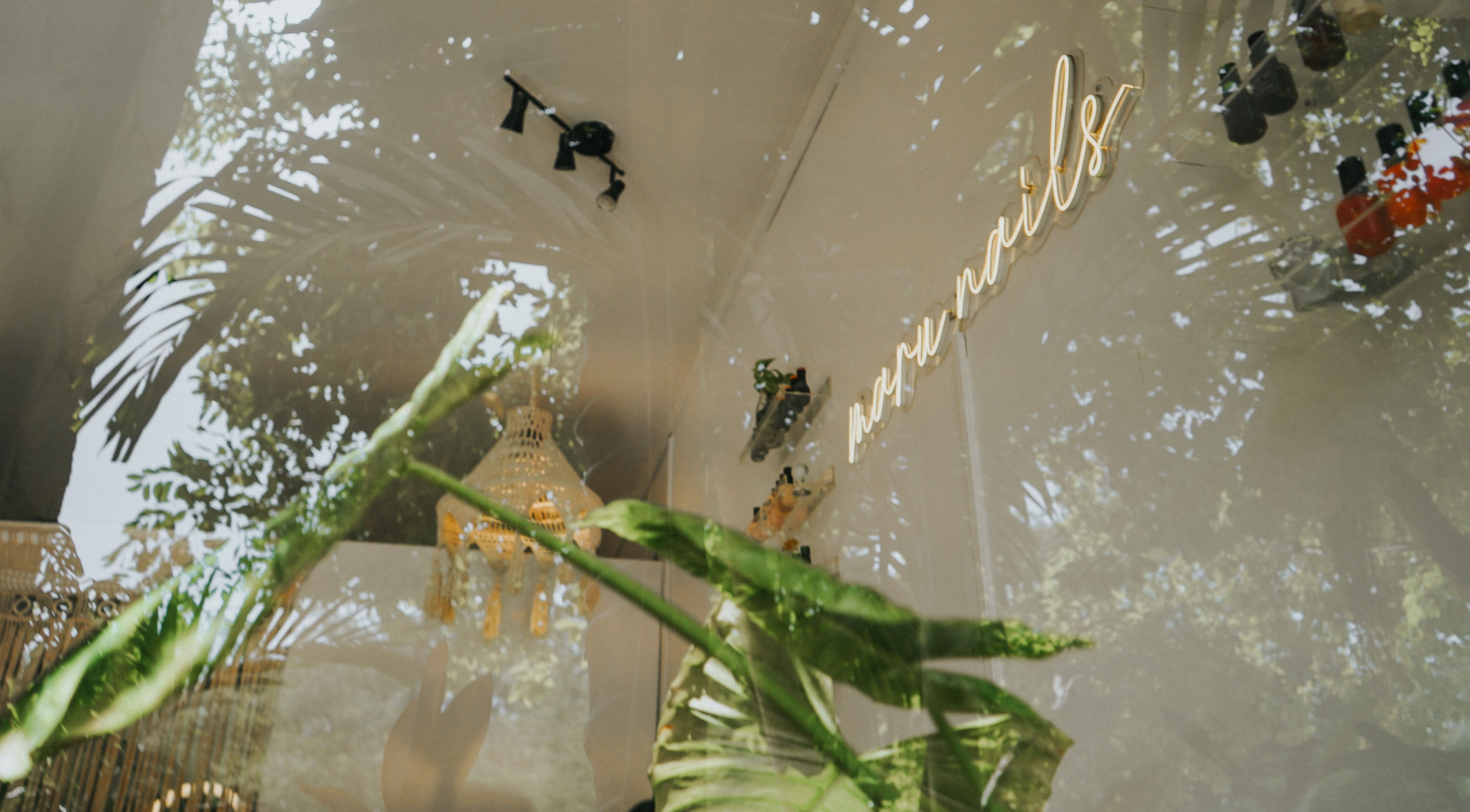 Vista exterior de Maru Nails Boutique Beauty Studio en Tulum, Quintana Roo, MX con un reflejo de la naturaleza.