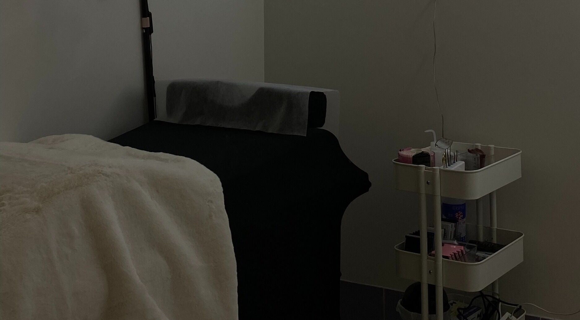 Treatment room at Glam By Aya, Brookvale, New South Wales, AU with a plush bed and a well-stocked cart.