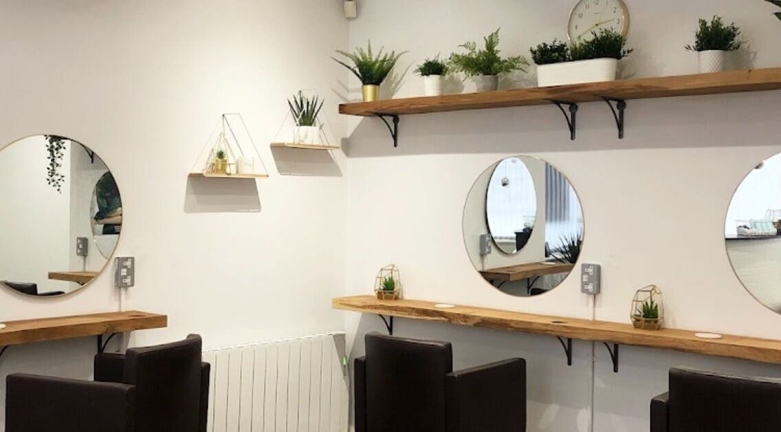 Modern hair salon interior at Hair By Poppy in Hull, England, GB with elegant mirrors and plants.