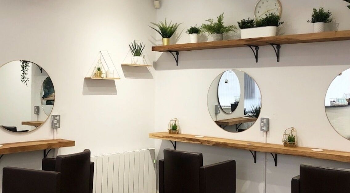 Modern hair salon interior at Hair By Poppy in Hull, England, GB with elegant mirrors and plants.