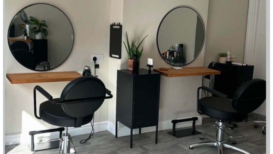 Modern hair styling stations at Izzy Ferguson hair in Ilkeston, England, GB with round mirrors and black chairs.