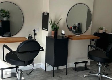 Modern hair styling stations at Izzy Ferguson hair in Ilkeston, England, GB with round mirrors and black chairs.