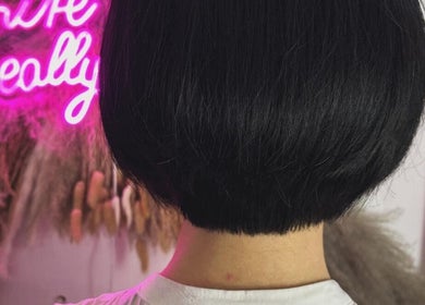 Elegant bob hairstyle at The Livingroom Oxford, located in Oxford, England, GB with vibrant neon decor.