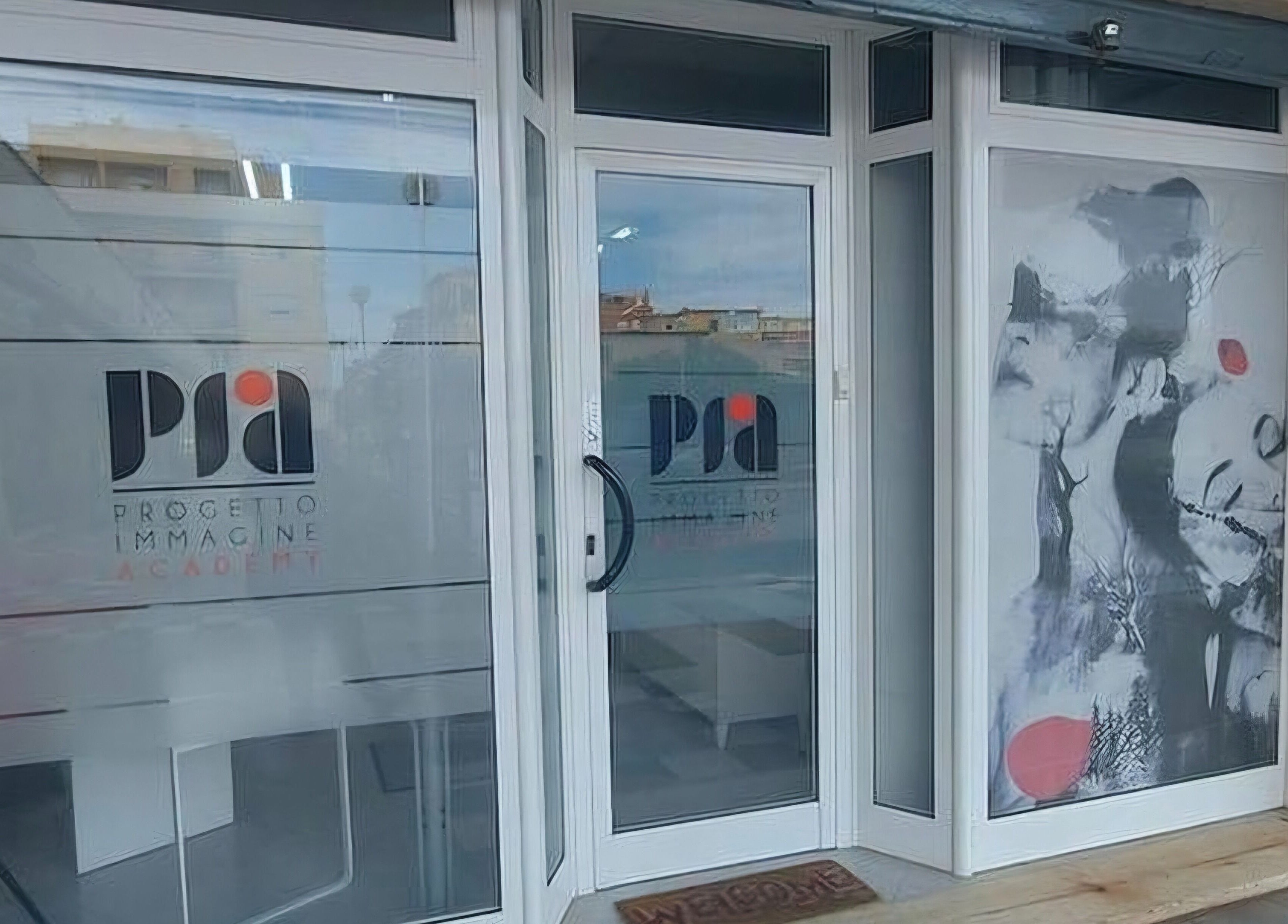 Ingresso moderno di PIA Progetto Immagine Academy a Roma, Lazio, IT con vetrate e grafiche artistiche.