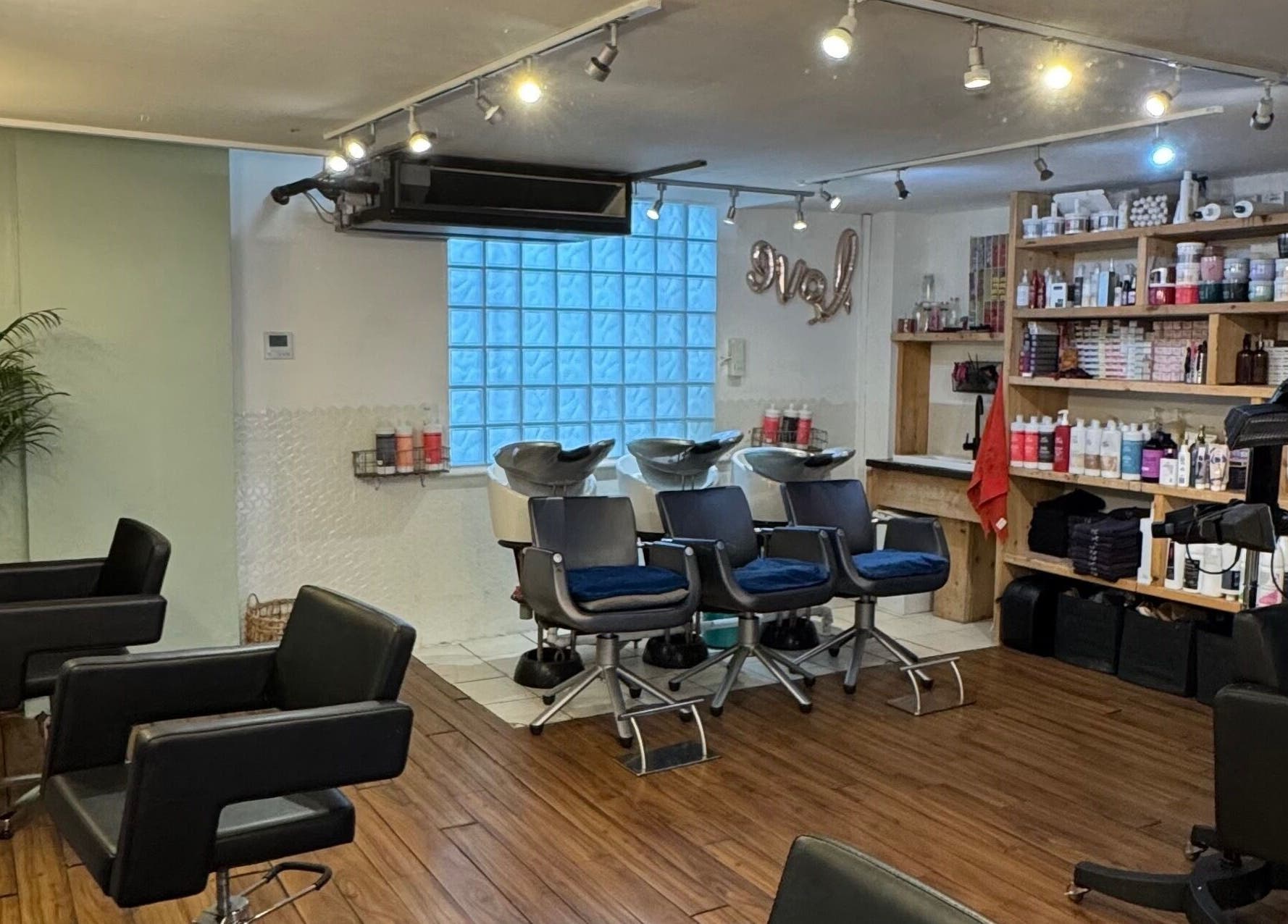 Spacious hair salon interior at The Studio by Marco Dias, Dublin, County Dublin, IE with chairs and styling products.