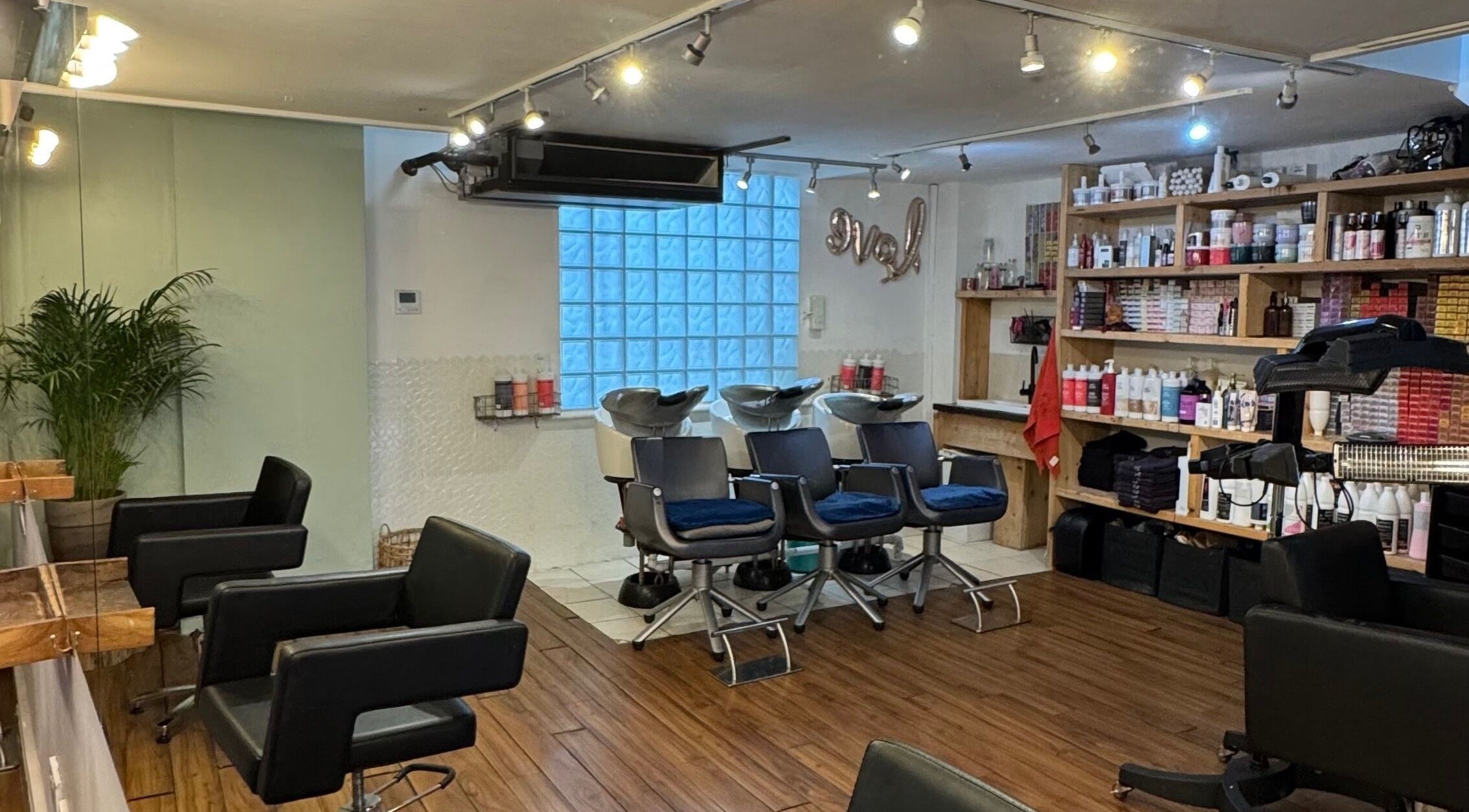 Spacious hair salon interior at The Studio by Marco Dias, Dublin, County Dublin, IE with chairs and styling products.