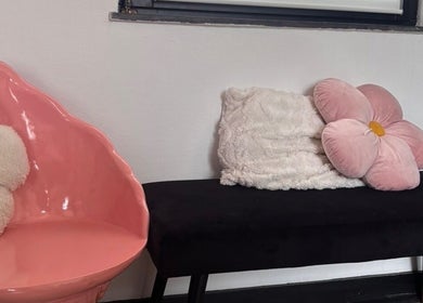 Fauteuil rose en forme de pétale chez Ink.No, Blégny, Région Wallonne, BE avec coussins fleuris.