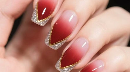 Elegant nail art with red ombre and glitter detail at Aria Nail, Massage & Head Spa, Fairfax, Virginia, US.