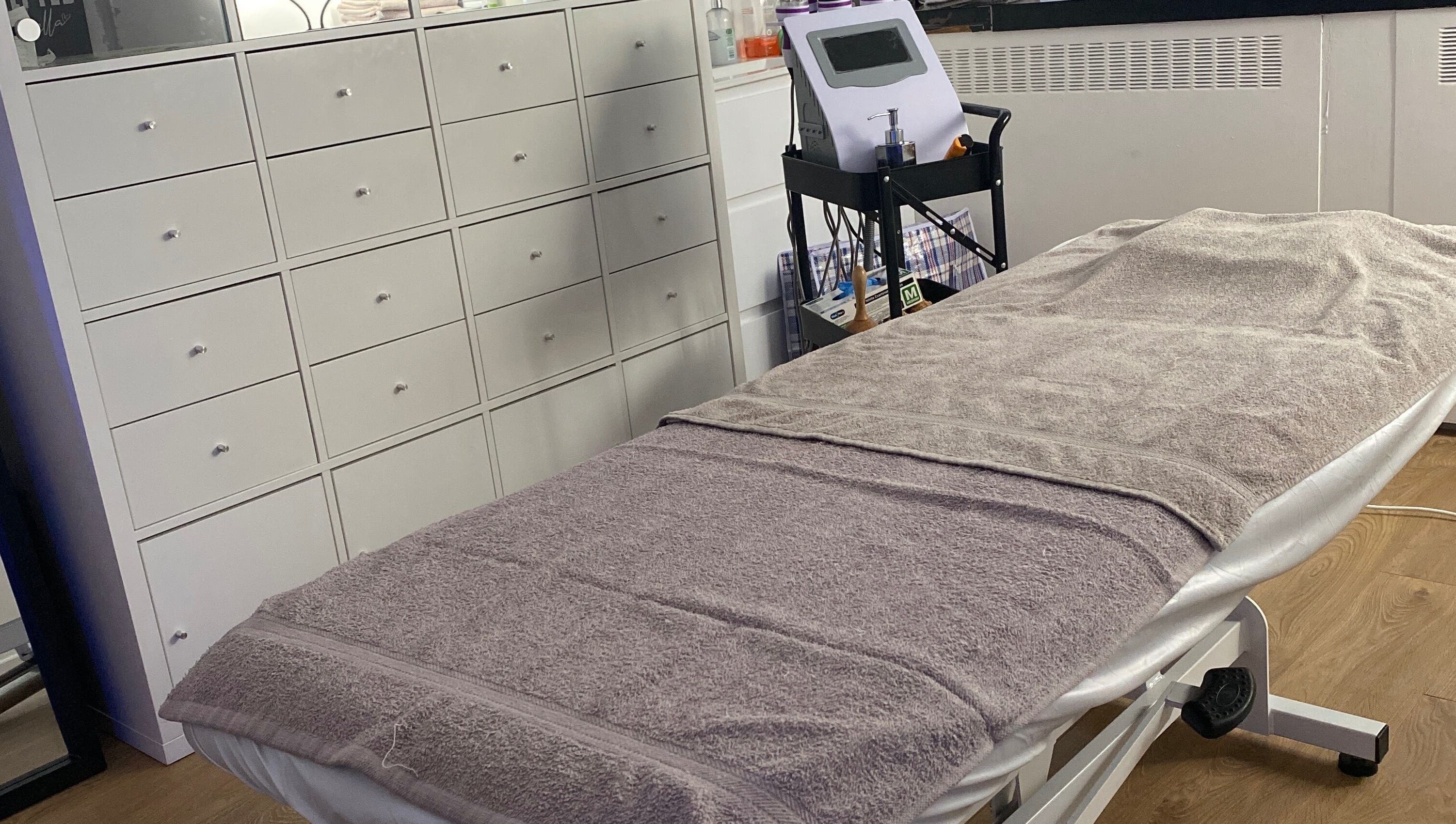 Cozy treatment room at Sculpted By Ariella, Cheltenham, England, GB with a comfortable therapy bed.