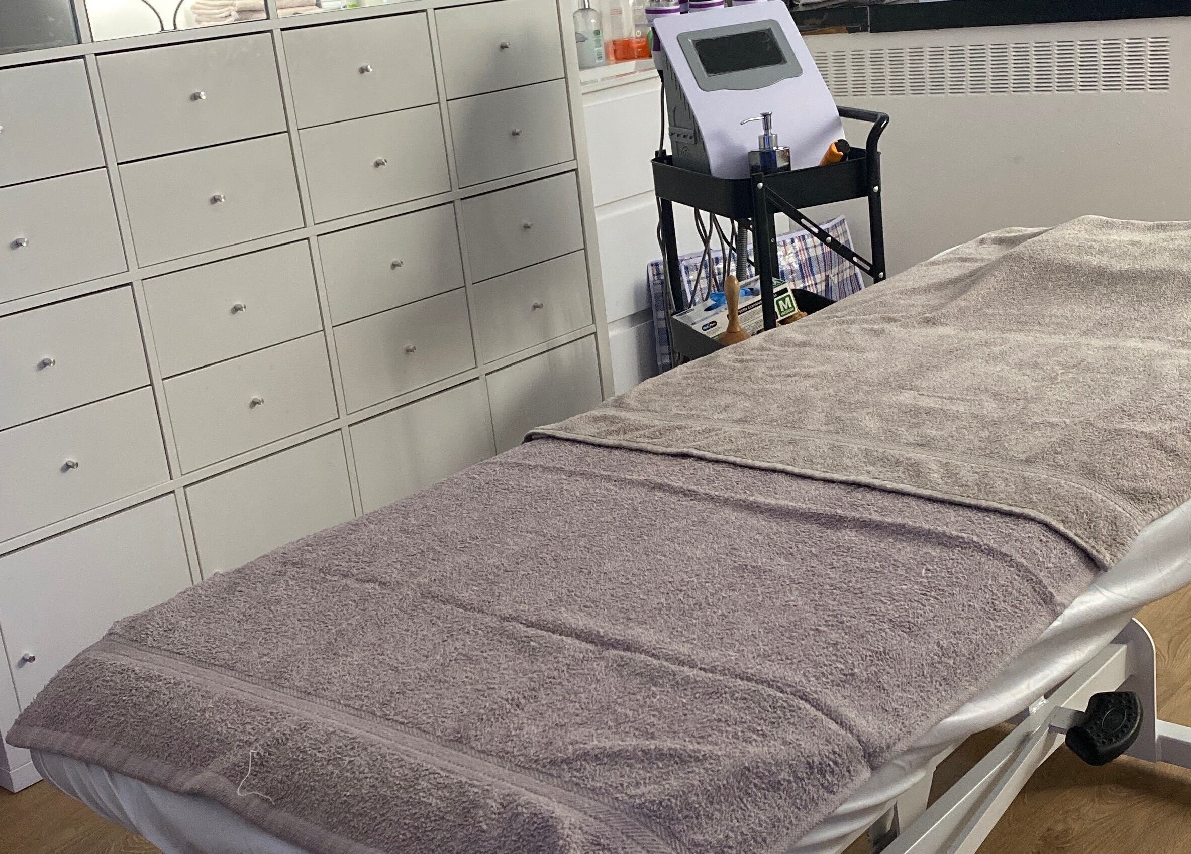 Cozy treatment room at Sculpted By Ariella, Cheltenham, England, GB with a comfortable therapy bed.