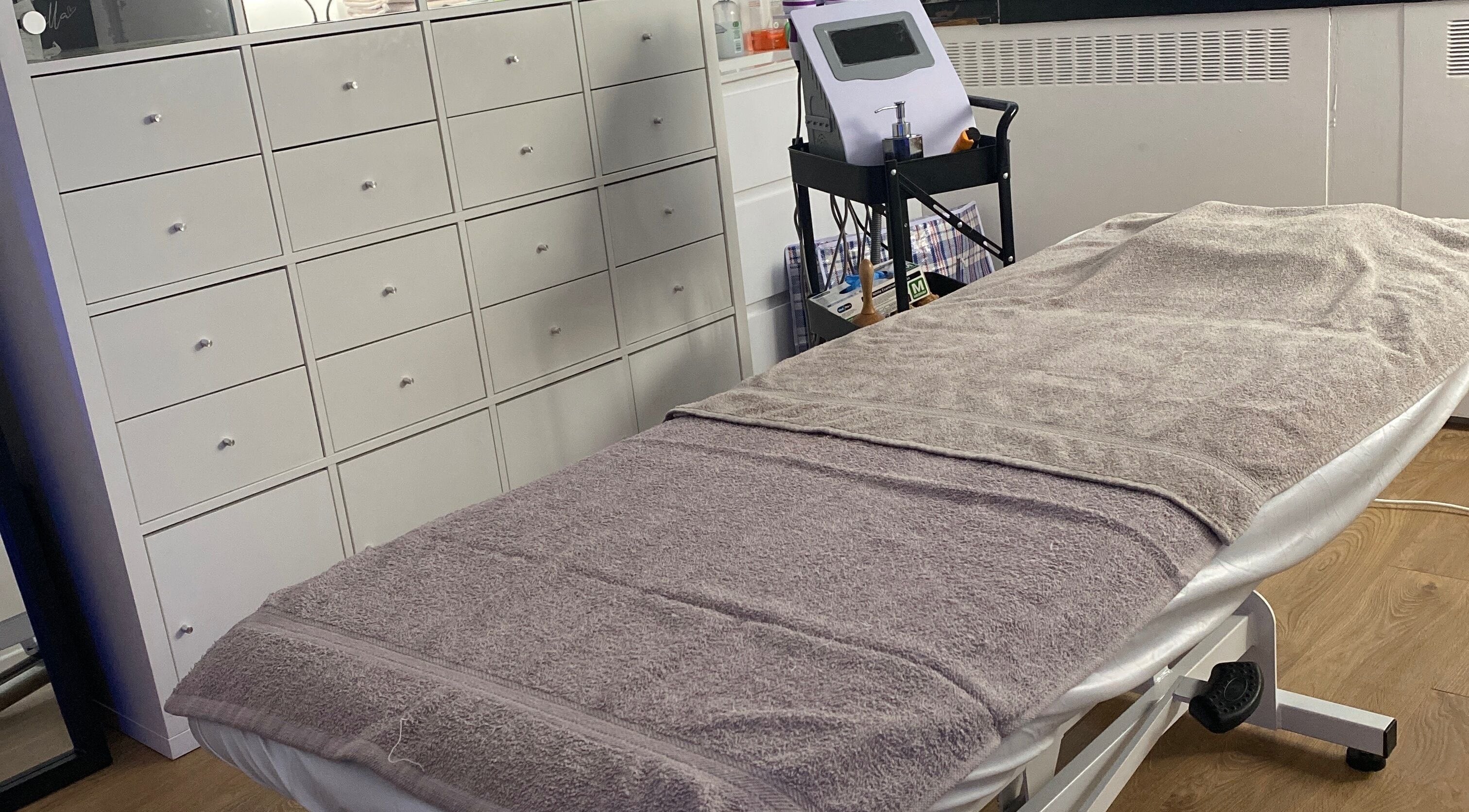 Cozy treatment room at Sculpted By Ariella, Cheltenham, England, GB with a comfortable therapy bed.