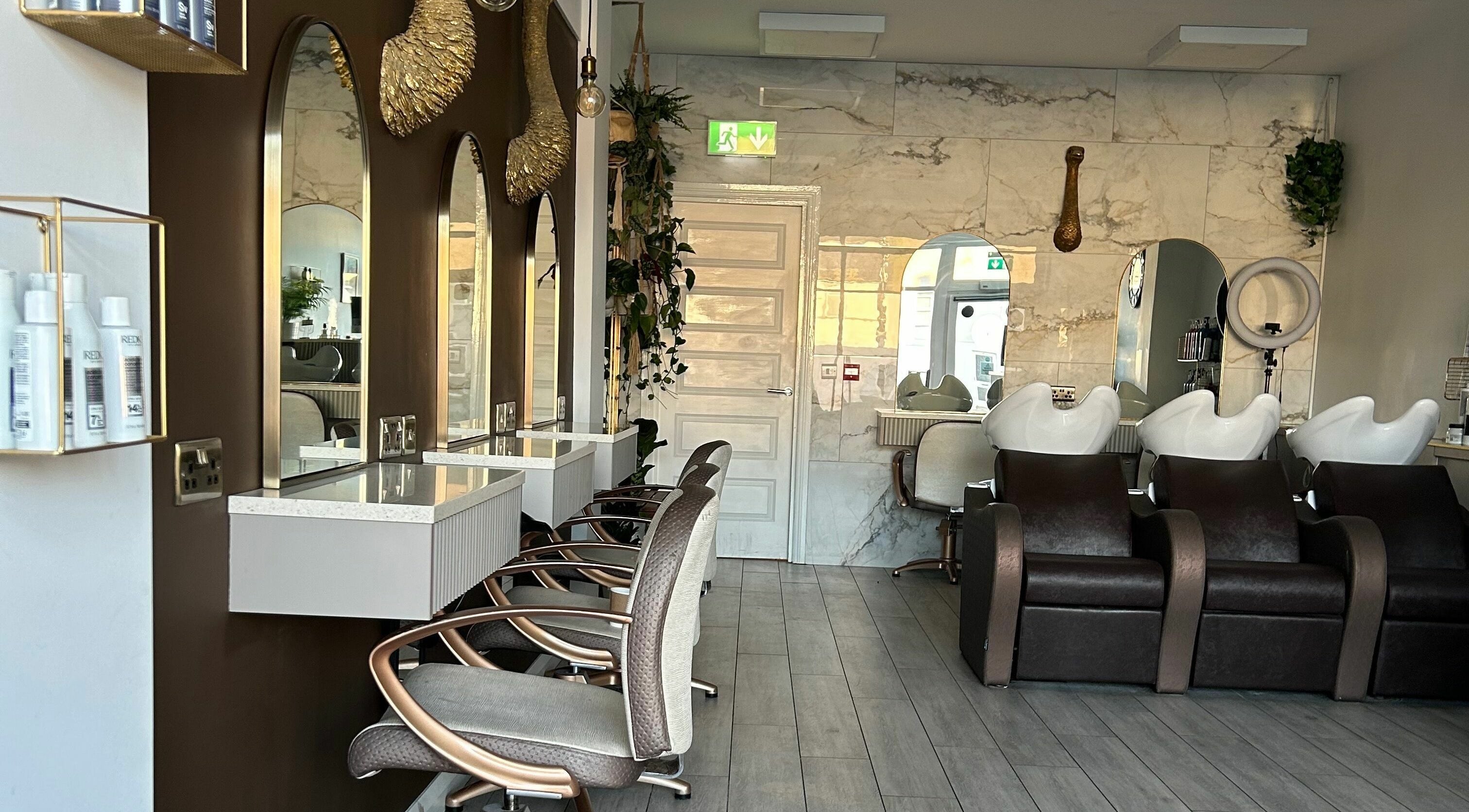Elegant interior of V-Vault House Of Hair in Kilrea, Northern Ireland, GB with styling stations and plush seating.